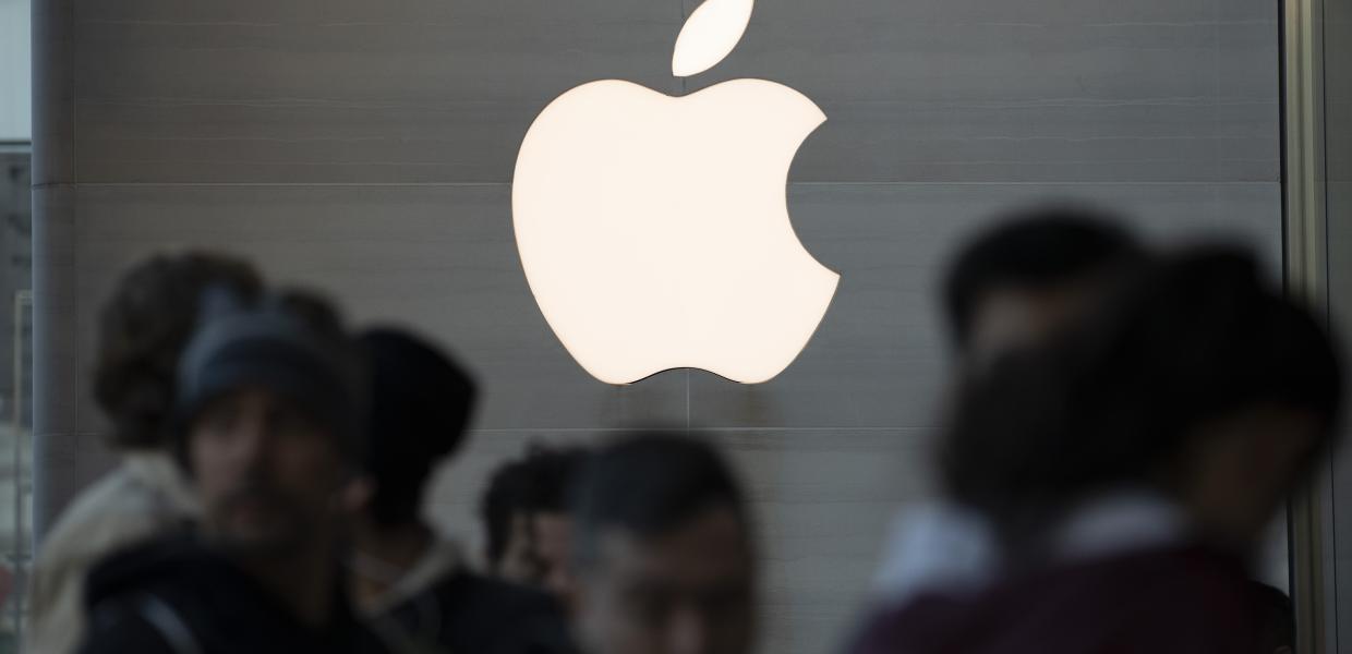 Το λογότυπο της Apple και μπροστά κόσμος σε κατάστημα