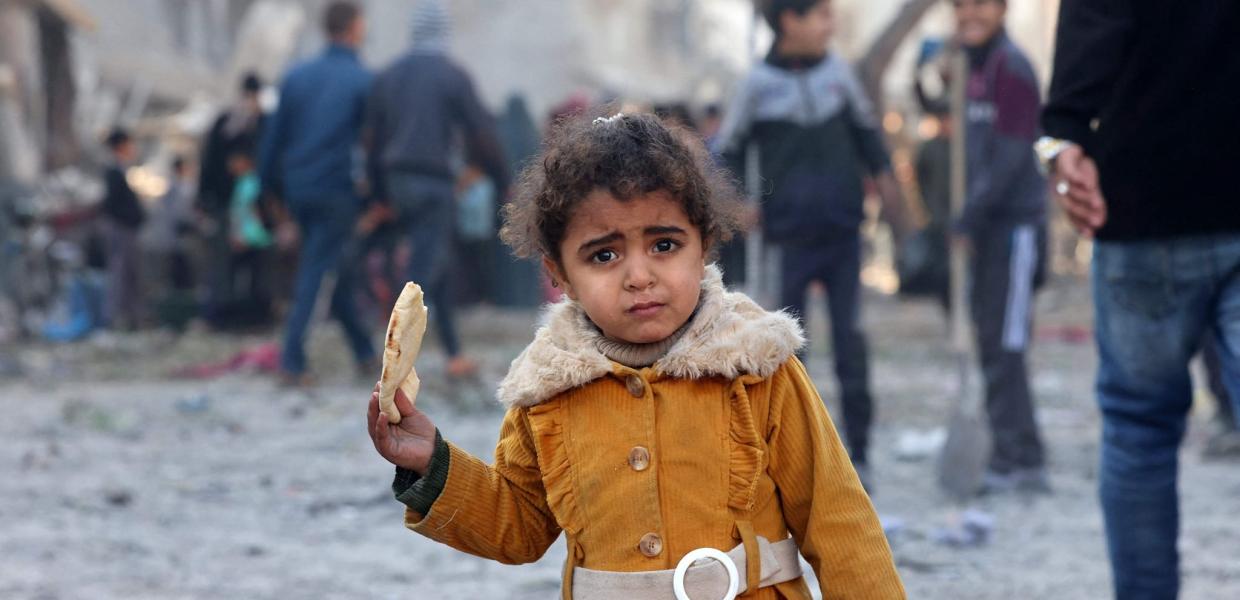 Φοβισμένο κοριτσάκι στην Παλαιστίνη που κρατά στο χέρι του ψωμί